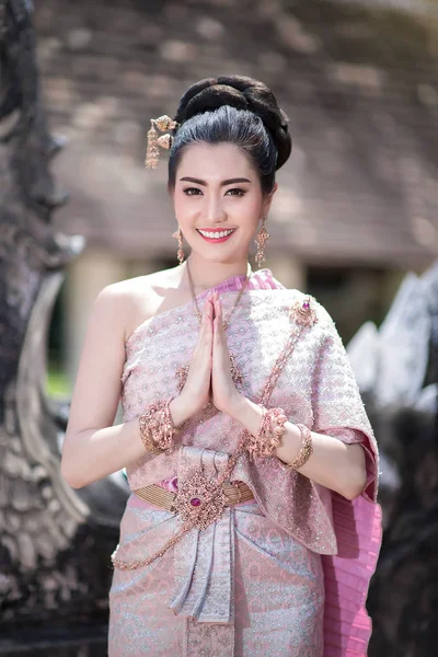 Thai wai greeting in traditional clothing